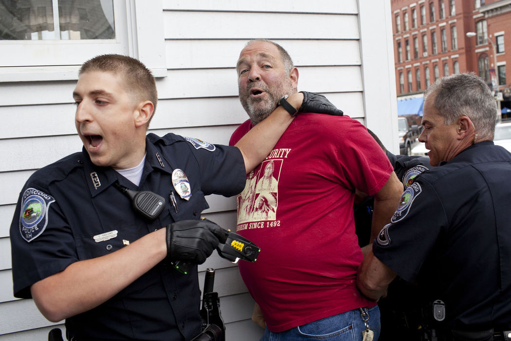 Award of Excellence, Spot News - Small Market - Taehoon Kim / Ohio UniversityDaniel Musso, of Brentwood, N.H., is apprehended by law enforcement officers during a gun control rally supported by Mayors Against Illegal Guns in Concord, N.H..