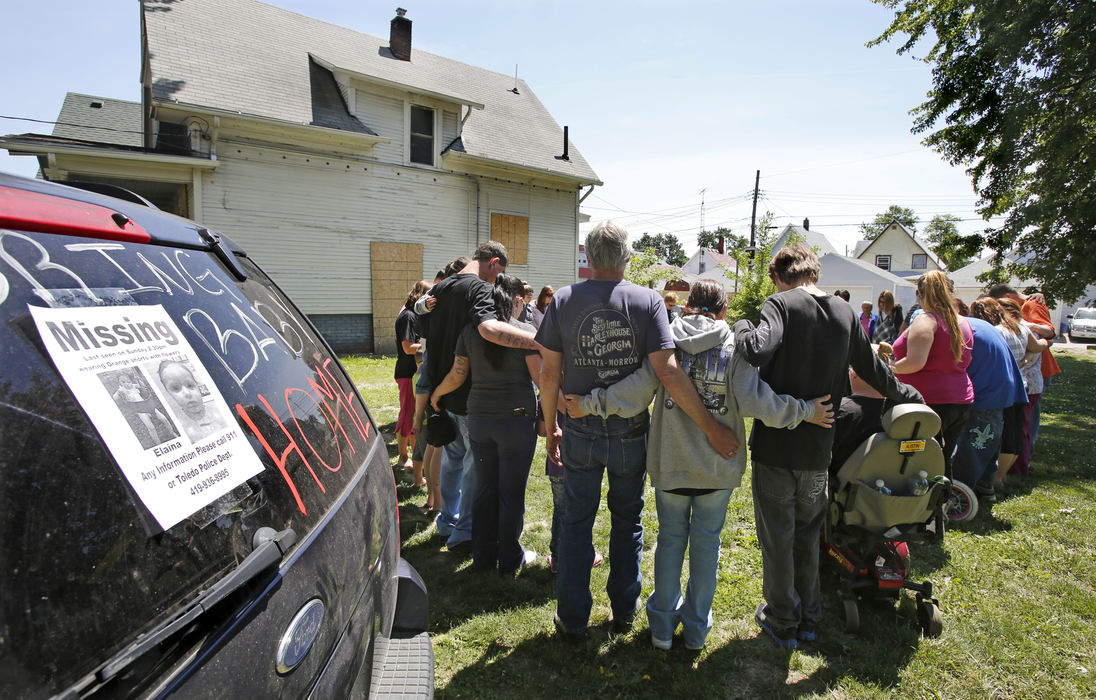 First Place, Team Picture Story - Dave Zapotosky / The (Toledo) Blade Overview:  18-month-old Elaina Steinfurth went missing on June 2.Elaina, her 4-year-old sister, and their mother, Angela Steinfurth stayed with the family of ex boyfriend Steven King II on June 1.Elaina's father, Terry Steinfurth, went to the residence to pick up his two daughters the next day, but only Elaina's four-year-old sister could be found.  Her disappearance drew worldwide attention.Based on misleading information provided by Angela Steinfurth, authorities began a months long search of homes, vacant buildings and the Maumee River near downtown for any sign of Elaina while volunteers looked through neighborhoods and parks. Several marches and rallies  calling for justice for Baby Elaina were held.  The toddlers skeletal remains were ultimately found in a garage on the King family property.  Steinfurth and ex-boyfriend King were eventually arrested and pleaded guilty in the killing of baby Elaina.Caption: Friends and family of missing 1-1/2-year-old Elaina Steinfurth pray on Leonard Street in East Toledo on Tuesday, June 4, 2013. The girl was last seen on Sunday. 