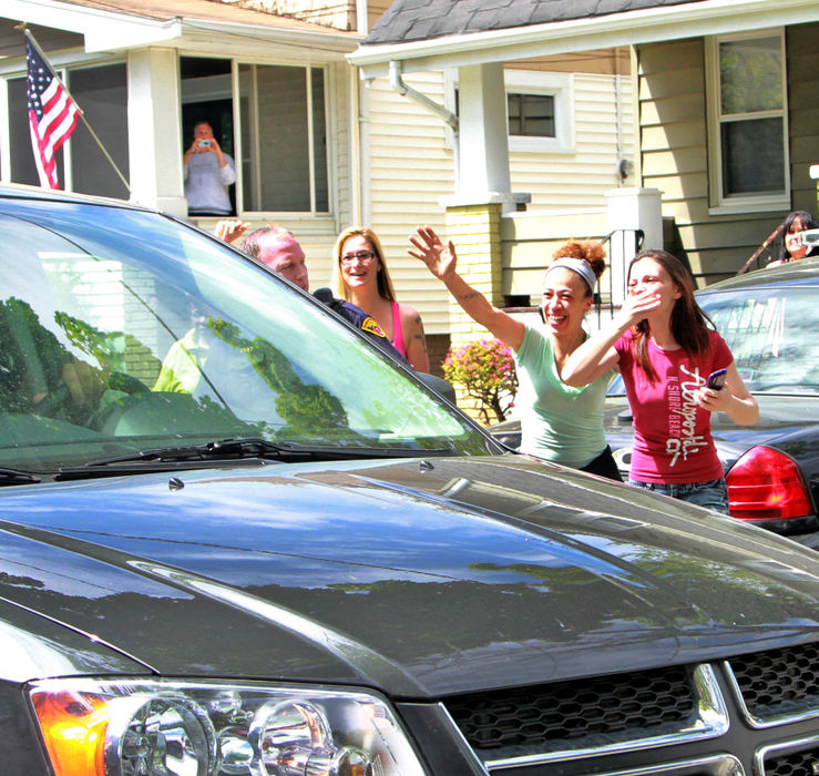 Second Place, Team Picture Story - Lynn Ischay / The Plain DealerA car bringing Gina DeJesus to her sister's house on West 129th Street in Cleveland is greeted by neighbors celebrating her freedom two days after her release.