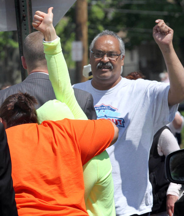 Second Place, Team Picture Story - Thomas Ondrey / The Plain DealerCovered by a hooded sweatshirt and shielded by her sister, Gina DeJesus flashes a quick "thumbs up" to cheering neighbors as she walks into her home for the first time in over 10 years.  Her father, Felix DeJesus, also raises his arm in triumph. 