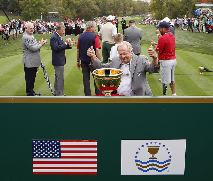 Third Place, Team Picture Story - Kyle Robertson / The Columbus DispatchThe Presidents Cup returned to U.S. soil in 2013 with six days of professional golfing excitement at Jack Nicklaus' Muirfield Village Golf Club in Dublin, Ohio. Held biennially since 1994, the Presidents Cup features head to head match play between a United States Team and an International Team each consisting of 12 of professional golf's best players. After 34 matches are played the winning team will have accumulated no less than 17.5 points. Despite the torment of heavy rains through out much of the tournament, fans and golfers tried to make the best of a United States victory over the International team 18.5 - 15.5. Jack Nicklaus places the Presidents Cup Trophy in on the 1st hole before the start of The Presidents Cup at Muirfield Village Golf Club in Dublin, Ohio on October 3, 2013.   