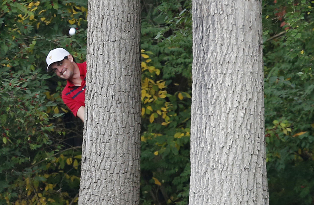 Third Place, Team Picture Story - Adam Cairns / The Columbus DispatchKeegan Bradley of the United States Team hits a shot from behind a tree on the 1st fairway during the fourth round of the Presidents Cup at Muirfield Village Golf Club on Oct. 5, 2013. 