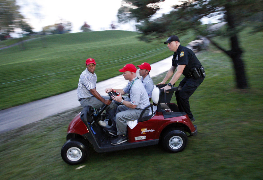 Third Place, Team Picture Story - Adam Cairns / The Columbus DispatchTiger Woods and Matt Kuchar of the United States Team are driven back to the clubhouse after play was called because of darkness during the second round of the Presidents Cup at Muirfield Village Golf Club on Oct. 4, 2013.