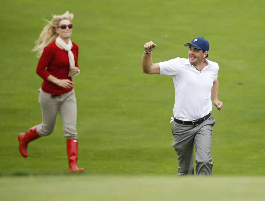 Third Place, Team Picture Story - Adam Cairns / The Columbus DispatchKeegan Bradley of the United States Team and Tiger Woods' girlfriend Lindsey Vonn run to the 18th green as it becomes obvious that the US team has clinched the win during the final round of the Presidents Cup at Muirfield Village Golf Club on Oct. 6, 2013.