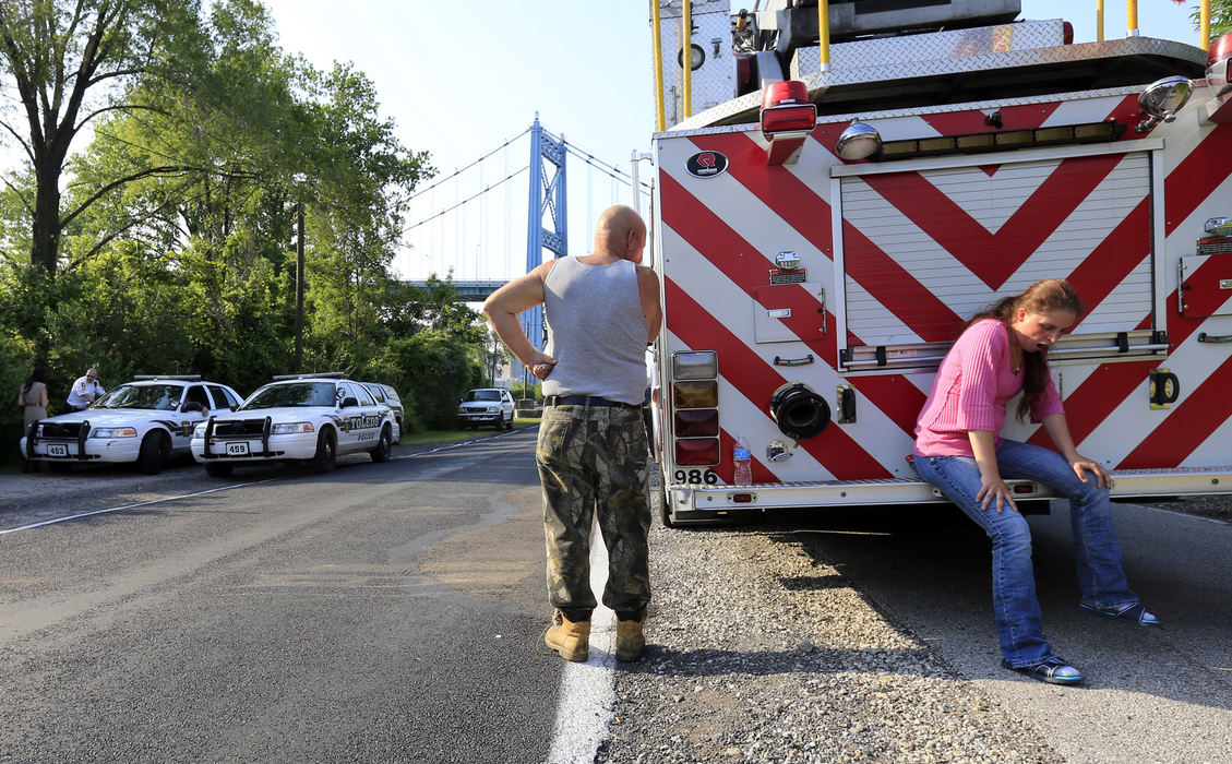 First Place, Team Picture Story - Andy Morrison / The (Toledo) Blade Richard Schiewe, left, and his stepdaughter Angela Steinfurth wait to hear news as Toledo Fire Department divers search the Maumee River for her missing daughter Elaina Steinfurth, 1, Thursday, June 6, 2013.  Angela had given law enforcement officials false information about the possible location of her missing daughter, leading them to believe her body was in the river.