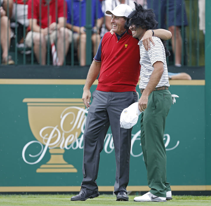 Award of Excellence, Ron Kuntz Sports Photographer of the Year - Chris Russell / The Columbus DispatchThe Presidents Cup is a series of men's golf matches between a team representing the United States and an International Team representing the rest of the world minus Europe. The event was plagued by torrential rains.Phil Mickelson of the United States Team poses for a picture with Charl Schwartzel of the International Team who had donned a fright wig before the start of during the Presidents Cup in Dublin, Ohio on October 3, 2013.  