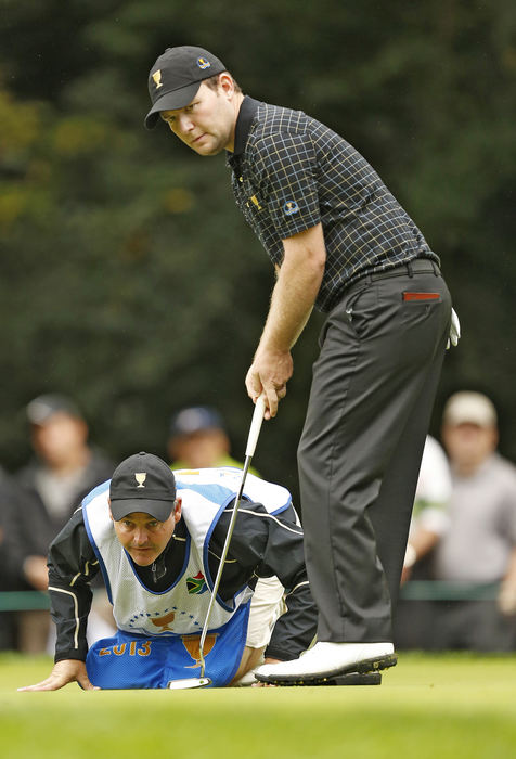 Award of Excellence, Ron Kuntz Sports Photographer of the Year - Chris Russell / The Columbus DispatchBranden Grace of the International Team looks over his putt at the second hole with the help of his caddy, Billy Foster during the final  round of the Presidents Cup at Muirfield Village Golf Club in Dublin, Ohio on October 5, 2013. 