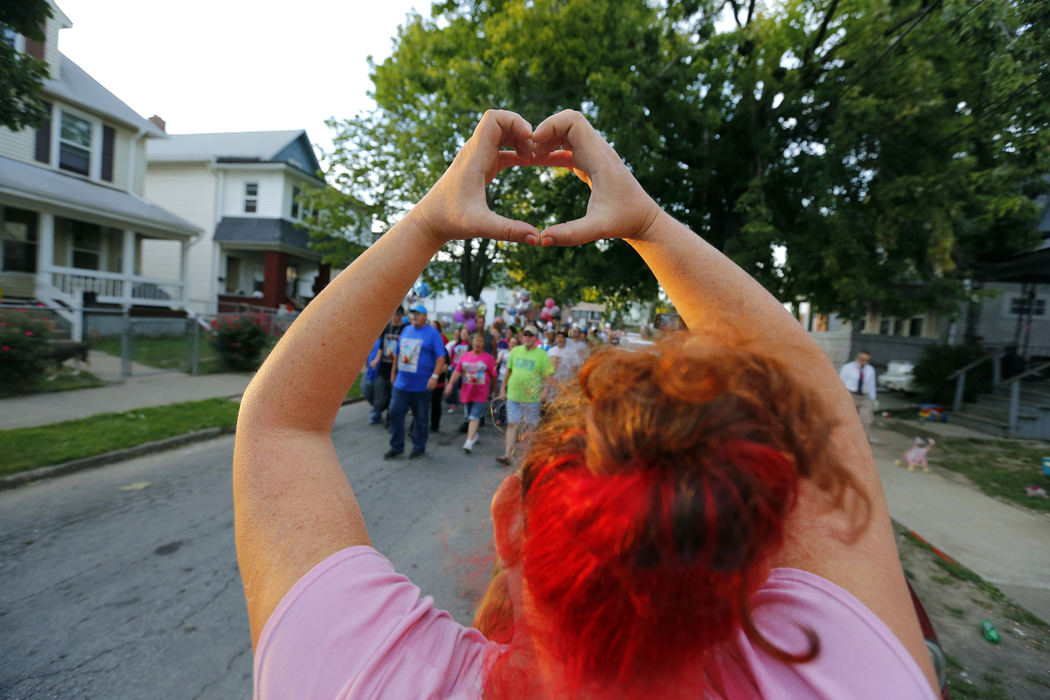 First Place, Team Picture Story - Andy Morrison / The (Toledo) Blade Cyndi Sting holds her hands in the shape of a heart as marchers continue down Federal during a vigil for Elaina Steinfurth at Federal and Leonard, Friday, Sept. 6, 2013. 