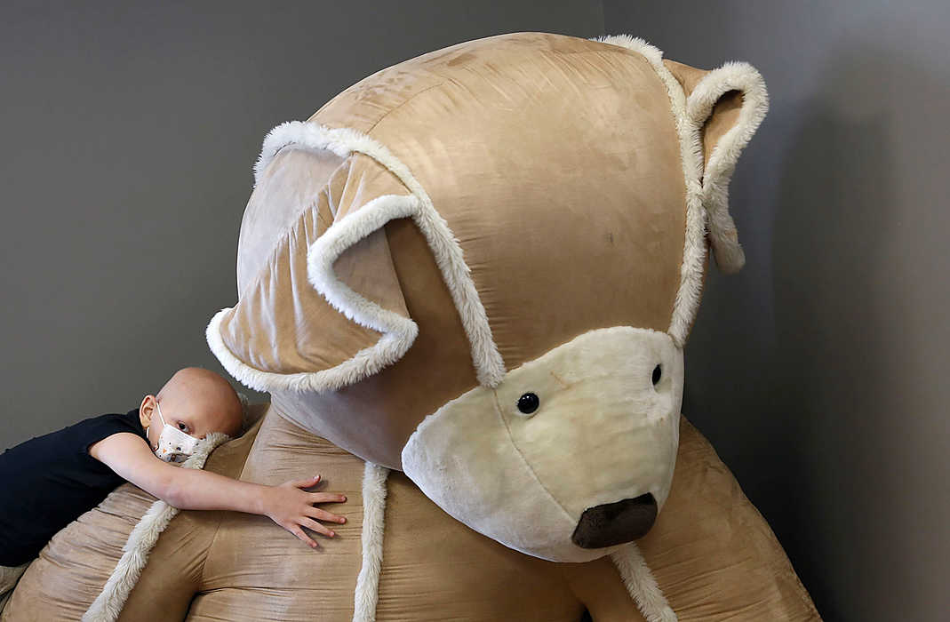 First Place, Feature - Chris Russell / The Columbus Dispatch Blaze Keim, rests atop a giant stuffed bear after playing with his sister at the Ronald McDonald House. Blaze is being treated for leukemia at Nationwide Children's Hospital and his sister will be donating bone marrow for his treatment. 