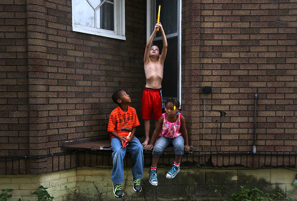 Award of Excellence, Feature - Katie Rausch / The (Toledo) BladeDevin Whaley (left) D.J. Ferrell (center) and Zyaire Whaley play together on their block in South Toledo. The kids had forwent their squirt guns even though the City of Toledo had declared the tap water safe to drink earlier that day after toxic algae in Lake Erie made the municipal water unfit for consumption for several days. D.J.'s mother, Krystalynn Ferrell, said she didn't trust the water just yet. "I'm pregnant, so I'm not taking any chances," she said. 