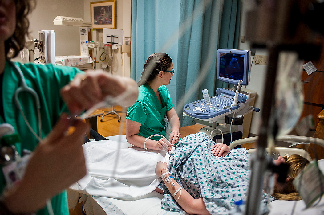 Third Place, Feature Picture Story - Logan Riely / Ohio UniversityDr. Gerlach gives an ultrasound on Jessica Cooper prior to her delivery making sure that the baby is facing in the right direction.