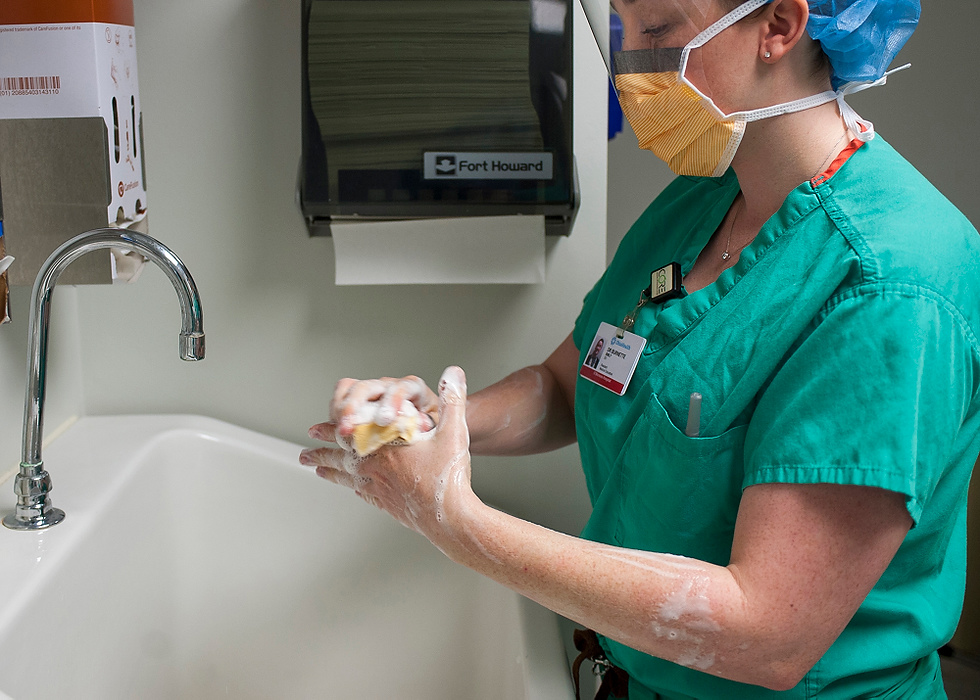 Third Place, Feature Picture Story - Logan Riely / Ohio UniversityDr. Burnette washes her hands in preparation for a C-section. 