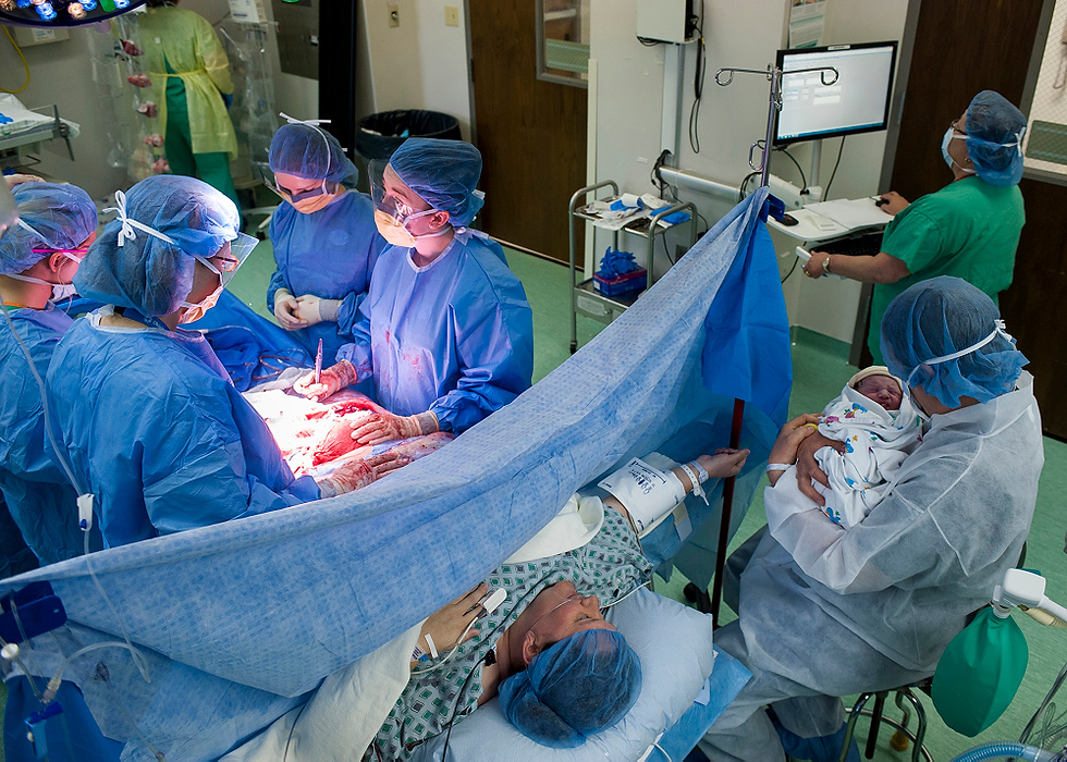 Third Place, Feature Picture Story - Logan Riely / Ohio UniversityDoctors tend to Samantha Smith after delivering her 9 lb. 1 oz. baby boy via C-section. This was Mrs. Smith's second child.  