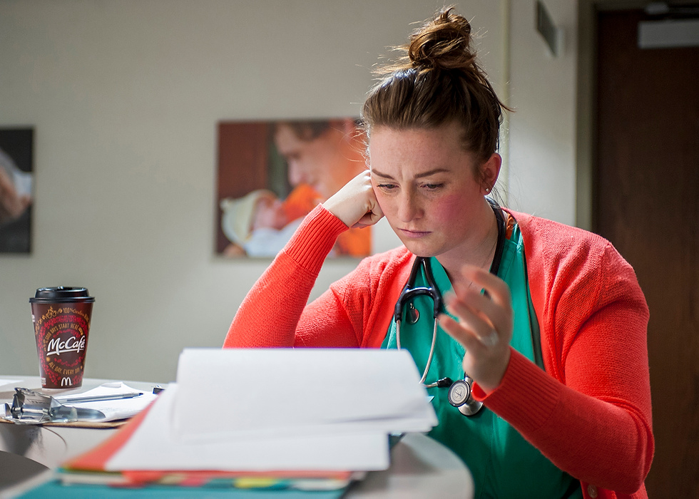 Third Place, Feature Picture Story - Logan Riely / Ohio UniversityDr. Emily Burnette looks over paper work before starting her evening rounds while on call one night. Dr. Burnette says, "without coffee I would not survive."
