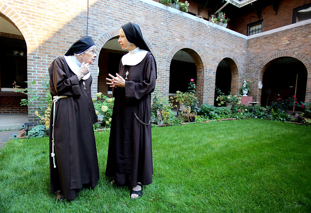 Award of Excellence, Feature Picture Story - Lisa DeJong / The Plain DealerMother Mary Thomas, 81, left, visits with Sister Mary Joseph, 51, in the garden of the Adoration Monastery at The Church of the Conversion of St. Paul.  Mother Mary Thomas, 81, has lived here as a cloistered nun of the Poor Clares of Perpetual Adoration for 55 years. She is one of the 18 nuns that live here in silence. Speaking is only allowed at certain times of day. 