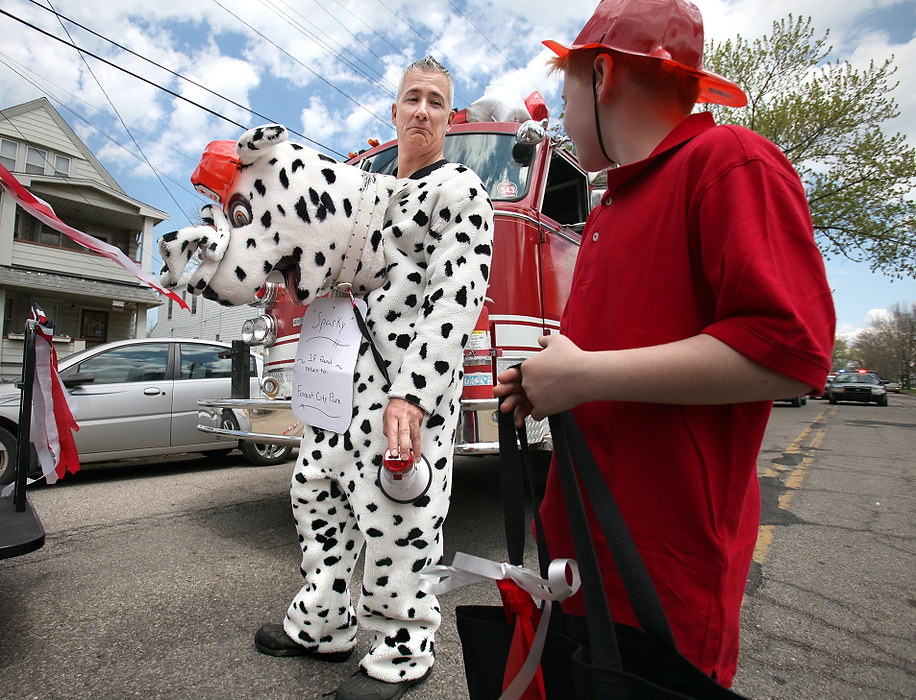 First Place, News Picture Story - Lisa DeJong / The Plain DealerBlaine Murphy gets creative as he tries to fit in to the small-town, working-class neighborhood. Murphy's attempts to get people to like him endears Murphy to many of the old-time activists in Slavic Village. Wearing a Dalmatian suit for his ride on the fire truck, "Sparky" waits for the start of the Cleveland May 3 Polish Constitution Day Parade. The parade celebrates the Polish constitution in 1791, a great source of pride and independence for Poland. Blaine Murphy was instrumental in organizing a Forest City group to march in the parade.