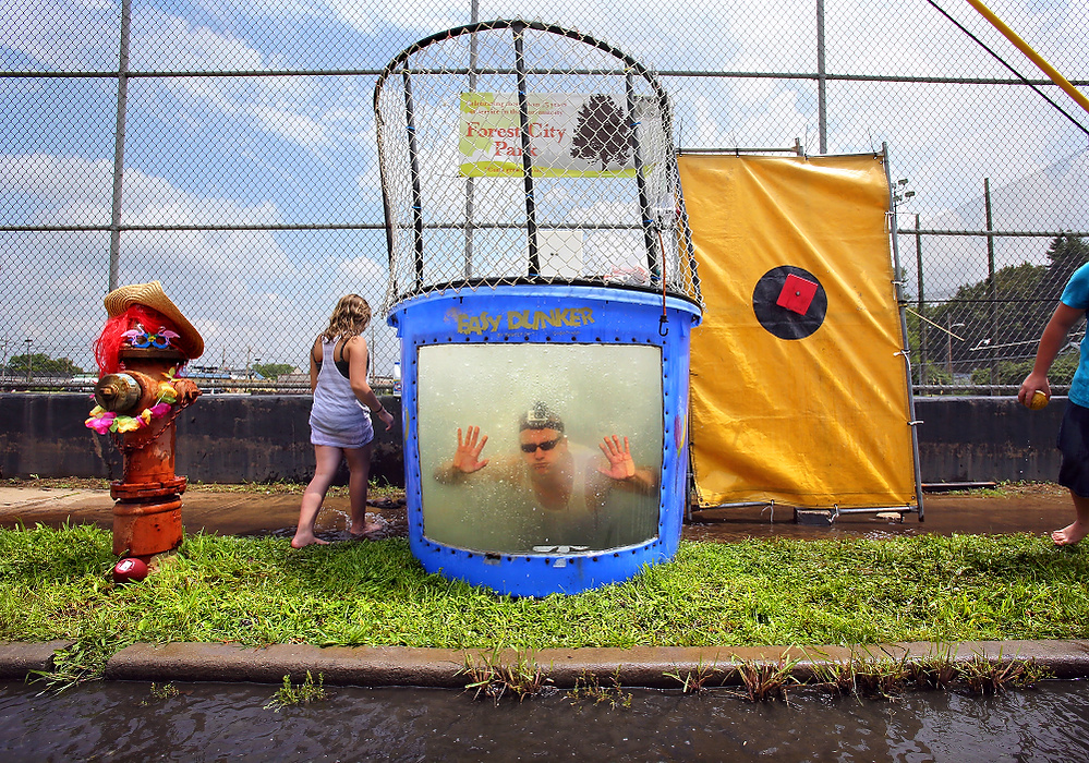 First Place, News Picture Story - Lisa DeJong / The Plain DealerBlaine Murphy gets creative as he tries to fit in to the small-town, working-class neighborhood and rents a dunk tank. Blaine Murphy plunges into the dunk tank after a young girl throws the softball onto the bullseye. Blaine Murphy, "The Flipper" and Cleveland City Councilman Tony Brancatelli both volunteered to be dunked during the annual "Feet on Fleet" festival in Slavic Village. Murphy's attempts to get people to like him endears Murphy to many of the old-time activists in Slavic Village.  