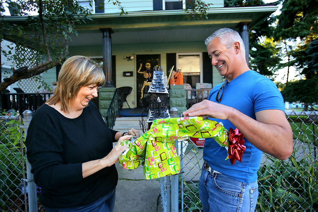 First Place, News Picture Story - Lisa DeJong / The Plain DealerBlaine Murphy, right, gives Lynda Lewis a Halloween gift of a haunted house at her home in Slavic Village.  As Slavic Village neighbors surprisingly opened their arms to him, Murphy learned more about their forgiving character then he deserved. Long-time neighborhood activists like Lewis knew Murphy was the catalyst Slavic Village needed. Her home was his punishment, his prison. Knowing they were on borrowed time, Lewis and Murphy started the momentum cleaning up the neighborhood. Lewis now considers Murphy her son and will be crushed when he leaves.  