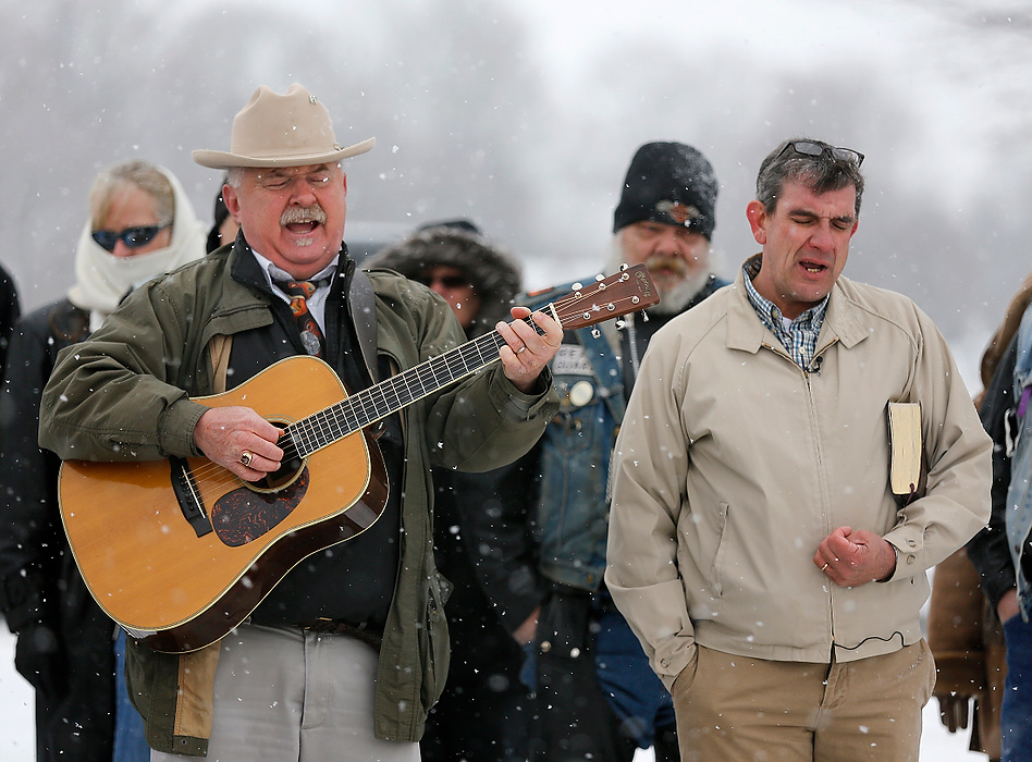 Second Place, News Picture Story - Jonathan Quilter / The Columbus DispatchBill Purk (left) and Jim Mayo, longtime friends of Bill Standley, sing an old George Jones song Standley was famous for singing in a local bar: "He Stopped Loving Her Today" during his graveside service before he was lowered into the ground atop his 1967 Harley Davidson at the cemetery in Mutual, Ohio.