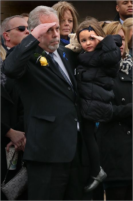 Third Place, News Picture Story - Ed Suba Jr. / Akron Beacon JournalRobert Winebrenner (left) and his granddaughter, Charlee Ayn, salute as the casket of his son and her father, Akron Police Officer Justin Winebrenner, is brought out after a memorial service for Winebrenner at the James A. Rhodes Arena in Akron.