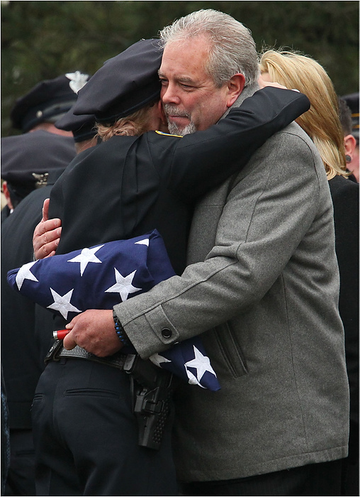 Third Place, News Picture Story - Ed Suba Jr. / Akron Beacon JournalRobert Winebrenner (right), father of slain Akron Police Officer Justin Winebrenner, receives a hug from an Akron police officer after the internment service at Holy Cross Cemetery in Akron.