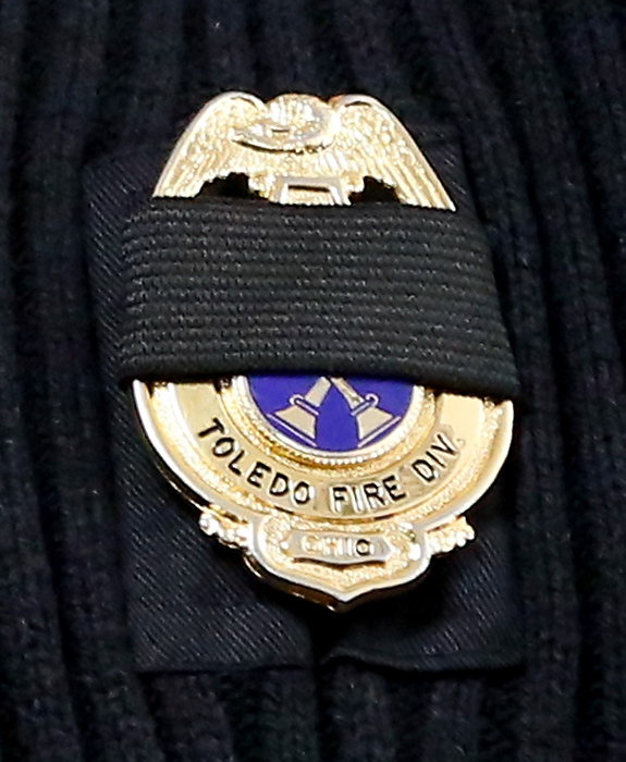 Award of Excellence, News Picture Story - Jetta Fraser / The (Toledo) BladeA mourning band over the badge of a Toledo Fire Department battalion chief after the deaths of two Toledo firefighters, Stephen Machcinski, 42, and James Dickman, 31, who died in the line of duty.