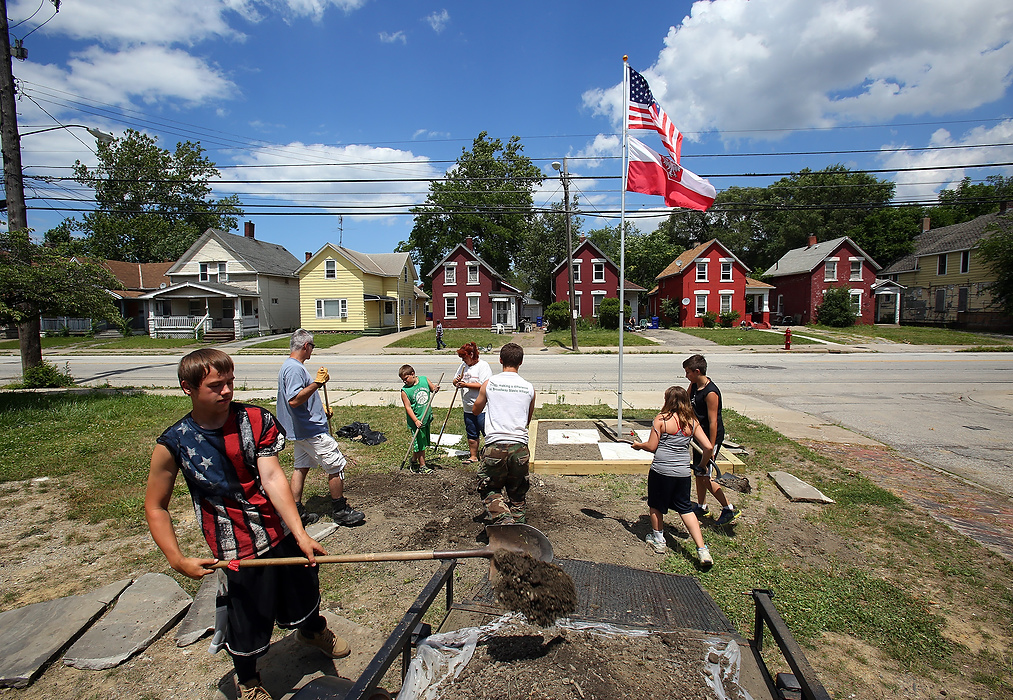 First Place, News Picture Story - Lisa DeJong / The Plain DealerLittle did Murphy know, Slavic Village needed him just as much as he needed them. Long-time neighborhood activists like Lynda Lewis knew Murphy was the catalyst Slavic Village craved. Blaine Murphy and some neighbors have tried to turn this vacant corner lot into a tiny park, erecting a flagpole and building a walking path to a seated area. Vandals keep coming back, time after time, destroying  the flagpole as well as defacing the stones with graffiti. Knowing they were on borrowed time, Lewis and Murphy started the momentum by boarding up houses, cleaning up over 2,000 tires, hauling away dumpsters of junk from vacant homes, creating parks, planting trees.  Life-long friendships blossomed. 