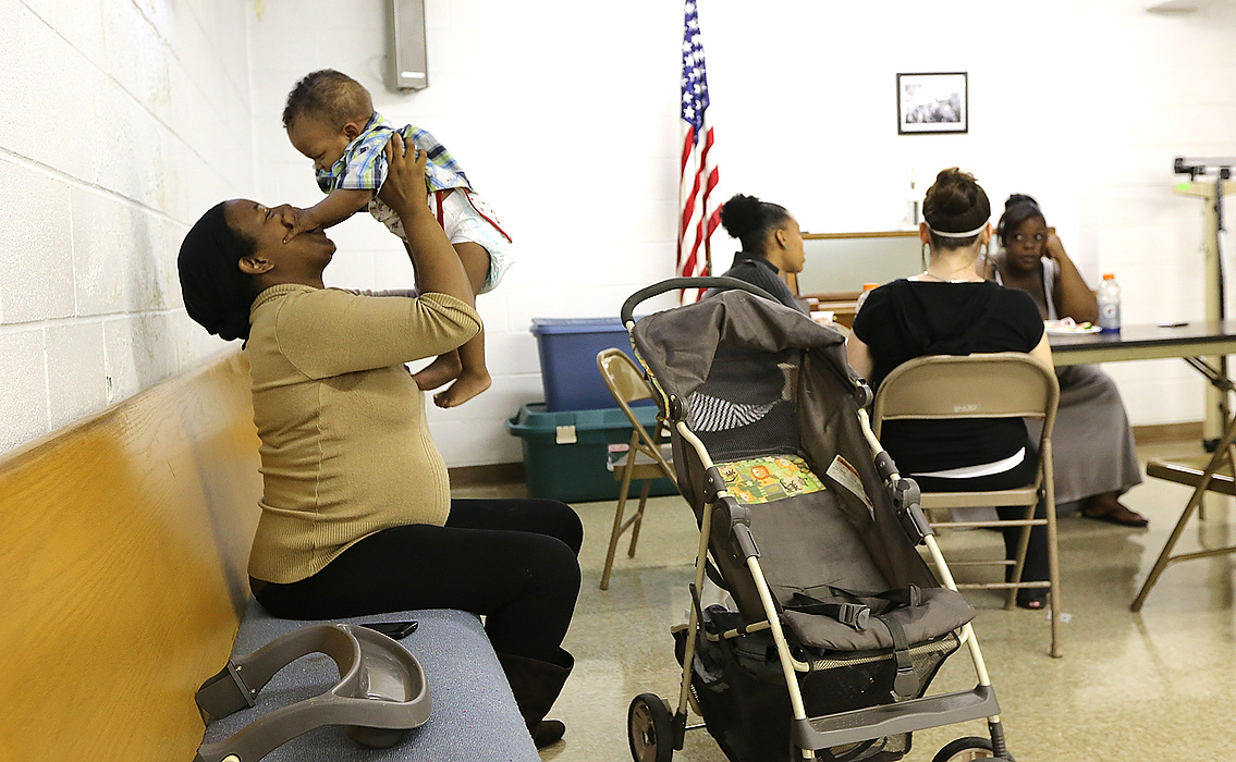 Second Place, James R. Gordon Ohio Understanding Award - Brooke LaValley / The Columbus DispatchCandy Chenault, who is 7 months pregnant, holds up her son Zion Hightower, 11 months, after changing his diaper during the "Moms to Be" program at the Grace Baptist Church on 6th Street in Columbus, Ohio on June 5, 2013. The "Moms to Be" program helps women who are pregnant and also those who are new mothers to create a community for them. 