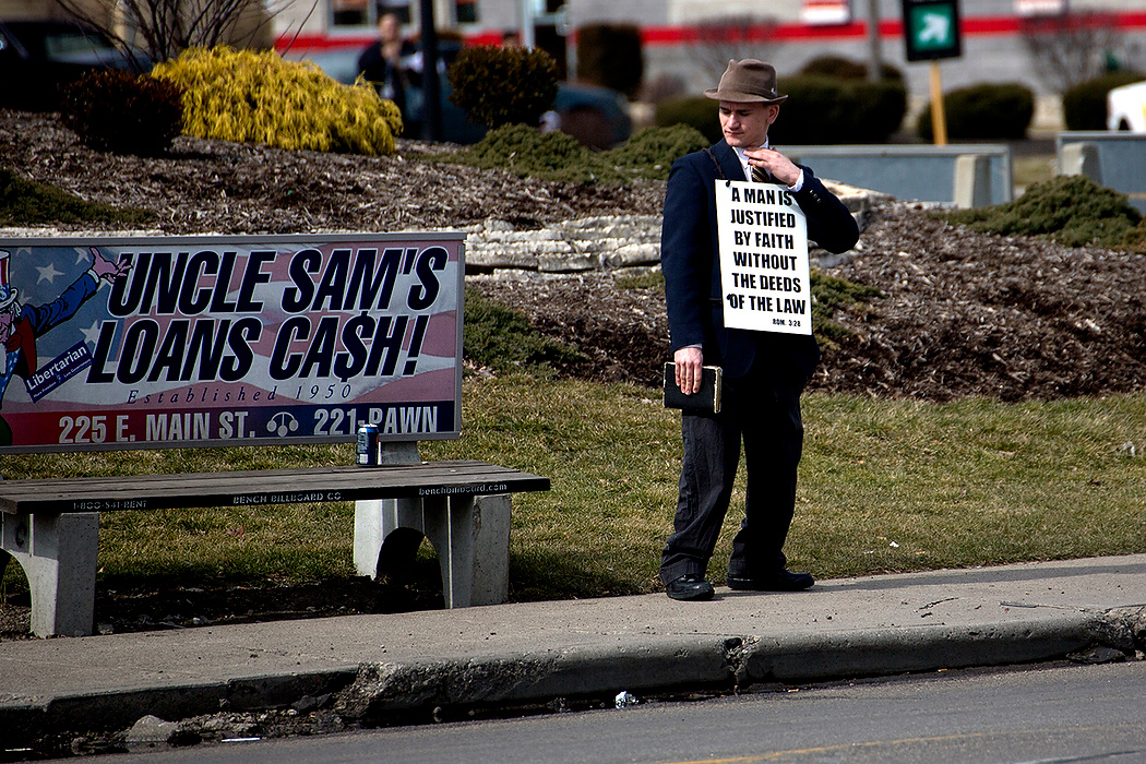 First Place, James R. Gordon Ohio Understanding Award - Jessica Phelps / Newark AdvocateA man stands on the corner of Broad and Central with a bible and sign preaching to passing cars. He is a member of one of the many churches that offer salvation in the "Bottoms."