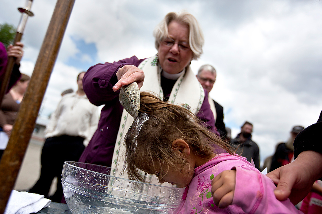 First Place, James R. Gordon Ohio Understanding Award - Jessica Phelps / Newark AdvocateEvery Sunday Rev.Lee Anne Reat hold a church service on the corner of Central Ave and Broad street. Before serving the meal after, she baptizes Mikayla and her siblings.