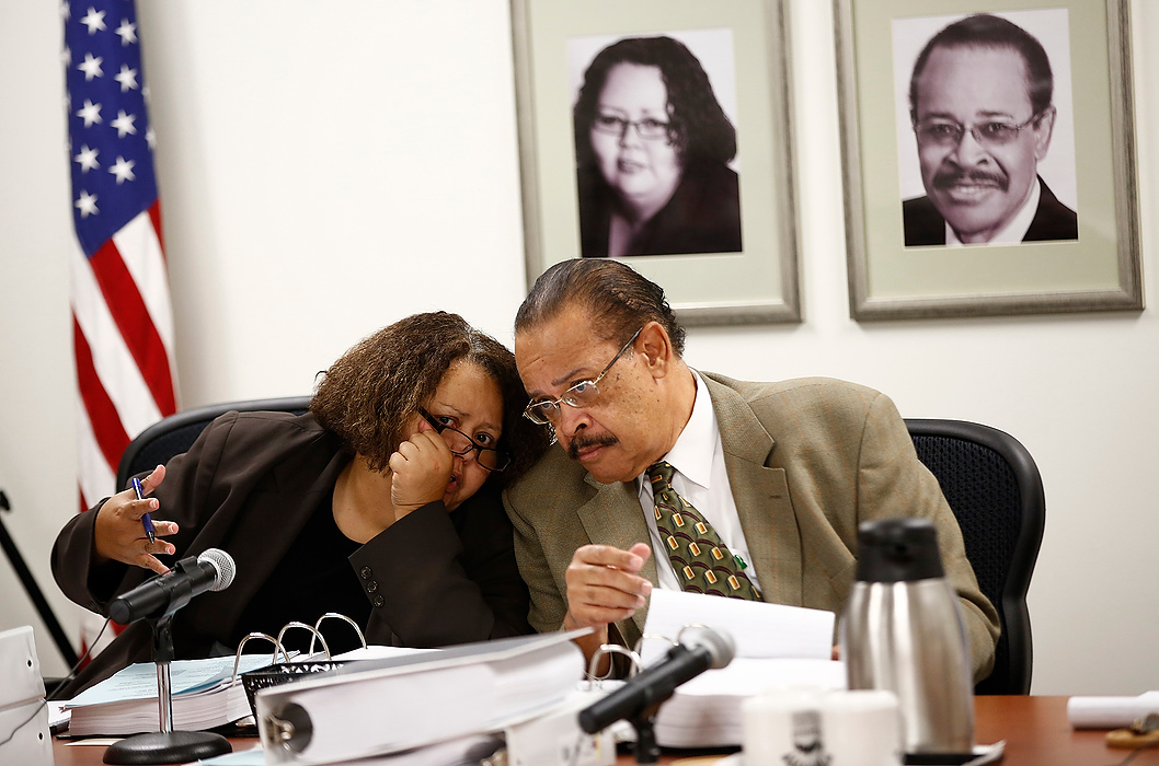 First Place, Photographer of the Year - Large Market - Eamon Queeney / The Columbus DispatchCommissioner Delena Edwards (left) and commission president Grady L. Pettigrew whisper during the Civil Service Commission hearing for former Columbus firefighter Marc Cain. Cain requested the hearing to try to get his job back after being terminated in March for dishonest, insubordinate and sexual behavior. 