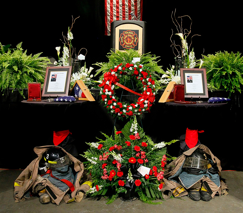 Third Place, Photographer of the Year - Large Market - Andy Morrison / The (Toledo) BladeToledo Firefighters James Dickman and Stephen Machcinski were killed in the line of duty on January 26th. A large memorial service was held for the pair with firefighters from all over the country attending. Dickman, who had yet to graduate with his class from The Toledo Fire and Rescue Department Training Bureau, was laid to rest in Sandusky, where he was from. The procession drove past the fire station where he formerly worked en route to the his final resting place. Tributes for Toledo firefighters James Dickman, left, and Stephen Machcinski stand beneath the stage before their Last Alarm funeral service at SeaGate Convention Centre. The pair were killed fighting a fire.