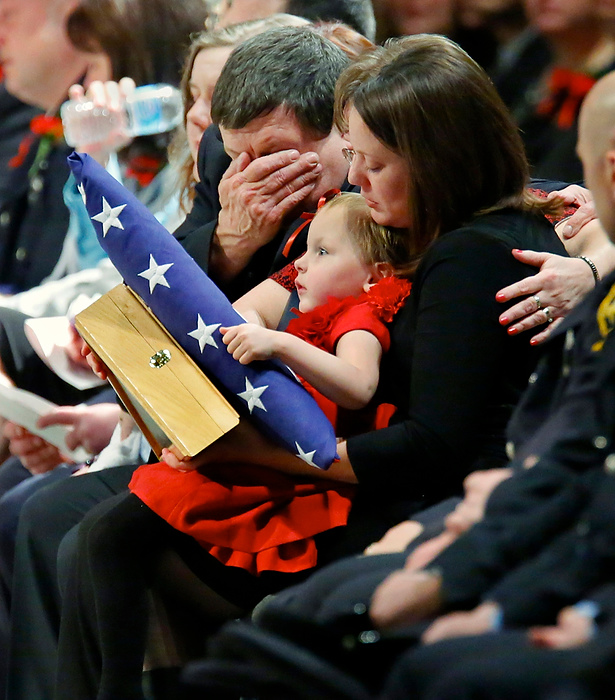 Third Place, Photographer of the Year - Large Market - Andy Morrison / The (Toledo) BladePaige Dickman, 3, daughter of Toledo firefighter James Dickman, holds American and Ohio flags while sitting on the lap of her mother Jamie, wife of Mr. Dickman, as she is consoled by his father Greg Dickman during the Last Alarm funeral service at SeaGate Convention Centre for Toledo firefighters Stephen Machcinski and James Dickman.