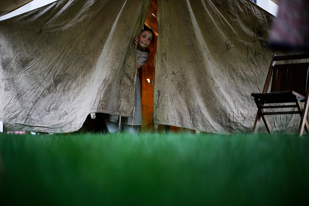 First Place, Photographer of the Year - Large Market - Eamon Queeney / The Columbus DispatchEmma Mason, 5, of Heath, peaks out of the Ladies Aid Society tent as her aunt Sara Rishel, of Zanesville, talks with a visitor on the lawn of the Ohio Statehouse during the 17th Civil War Encampment in Columbus. Sara said she tries to bring Emma out to play period dress up at least once a year and this time Emma was excited to get to see President Lincoln. Hosted by the 1st Ohio Light Artillery, Battery A, the event is open to the public Friday and Saturday from 9 am to 3 pm with canon firings every half hour and a host of different reenactors to learn from. 