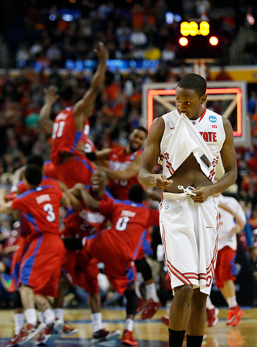 First Place, Photographer of the Year - Large Market - Eamon Queeney / The Columbus DispatchOhio State forward Sam Thompson (12) reacts as the Dayton Flyers celebrate their win in the background during the second half of the second-round NCAA Tournament game at the First Niagara Center. The Dayton Flyers defeated the Ohio State Buckeyes 60 - 59. 