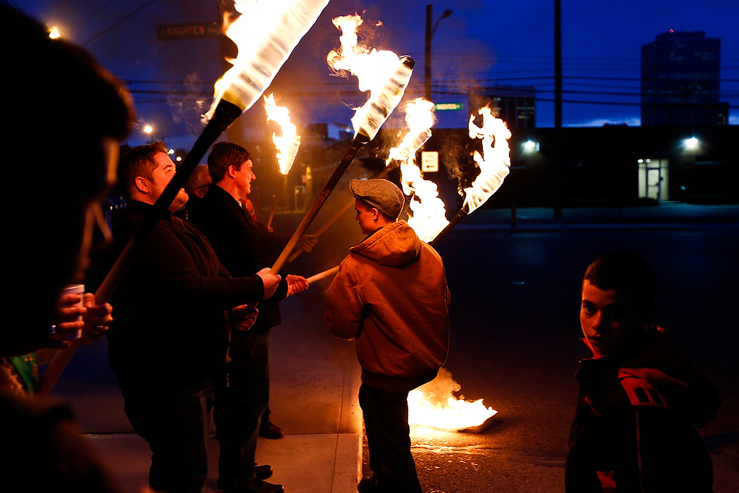 First Place, Photographer of the Year - Large Market - Eamon Queeney / The Columbus DispatchJustin Hernandez, center left, Jim Motter, center, and Conor Gerrity, center right, line up with other torch bearers in front of St. Patrick Church in downtown Columbus on St. Patrick's Day. St. Patrick Church hosted a special mass in honor of their patron saint today, which ended in a solemn procession around their block complete with torches and the carrying of their St. Patrick statue. 