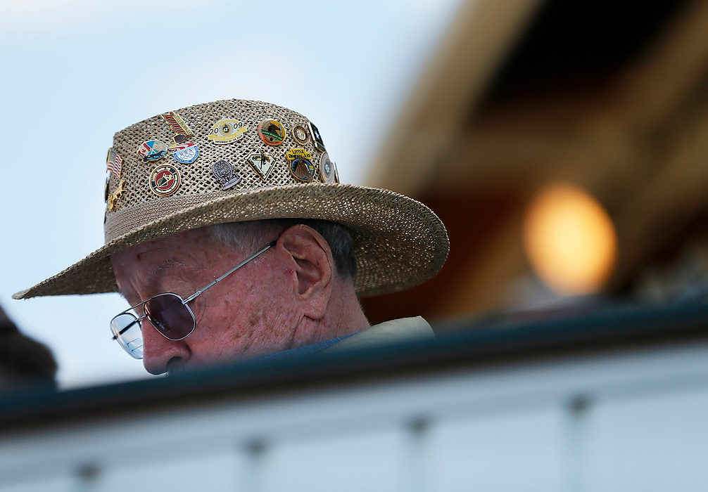 First Place, Photographer of the Year - Large Market - Eamon Queeney / The Columbus DispatchWith Little Brown Jug pins from different years decorating his hat Ray Seeley, of Hilliard, FL, reads his program between races during the 69th running of the Little Brown Jug at the Delaware County Fairgrounds, Thursday afternoon. Originally from the central Ohio area, Seeley has attended the jug 49 years in a row. "It's my once a year vacation," said Seeley. "I love coming here." Yannick Gingras driving Limelight Beach won the Little Brown Jug. 