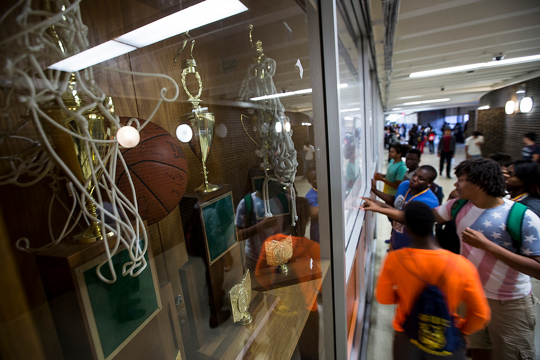 First Place, Photographer of the Year - Large Market - Eamon Queeney / The Columbus DispatchBetween classes students check out their field day teams for the next day as OHSAA State Championship trophies in boys basketball (2002), left, girls track and field (1998), center, and girls basketball (1996), right, sit in a case in the main hallway of Brookhaven High School. Notable alumni to go on to play professional sports include Paul O'Neill, retired MLB right fielder and 5-time MLB All-Star, Terry Glenn, retired NFL wide receiver, WNBA guard Helen Darling and NFL players Jeff Cumberland and Marlon Kerner. 