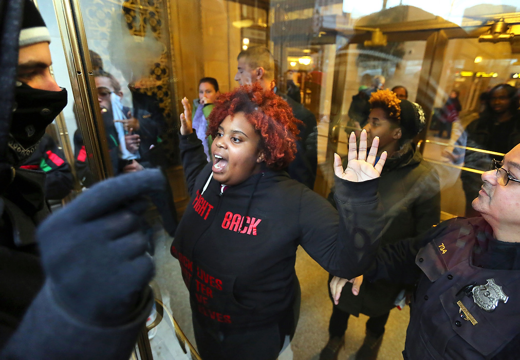 Second Place, Photographer of the Year - Large Market - Lisa DeJong / The Plain DealerA demonstrator, who walked in before police locked the doors, protests inside the doors of Tower City Center with fellow protesters outside the locked door of Tower City Center. Police unlocked the doors to let her out as the crowd agreed to move away from the doors.  Hundreds of demonstrators gather to protest the killing of 12-year-old Tamir Rice wo was fatally shot by rookie Cleveland police officer Timothy Loehmann seconds after he arrived to investigate a complaint about Rice carrying what turned out to be a fake gun. 