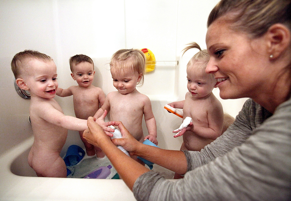 Second Place, Photographer of the Year - Large Market -  Lisa DeJong / The Plain DealerLeann Alferio, 33, right, squirts some Mr. Bubbles into the hands of her five children. The Alferio quintuplets are used to a crowded bath time in their cramped upstairs bathroom at their home in Medina. From left is Leighton, Giovanni, Kensley, Jade and Brooklynn (sitting on right but cannot see.) Their mother, Leann  washes each kid, then passes one off to a family member or friend to be dried off. It has been a whirlwind since Leann and her husband Jake Alferio, 29, had the quintuplets 19 months ago. "I don't care if you forget my birthday or if you don't get me anything for Christmas," Leann Alferio told her husband, Jake. "Just don't forget Mother's Day." Leann's mother, Sandy Miller, drives in from 2 hours away and stays from Monday to Friday during the day to babysit as Leann and Jacob work as teachers in Brunswick. 