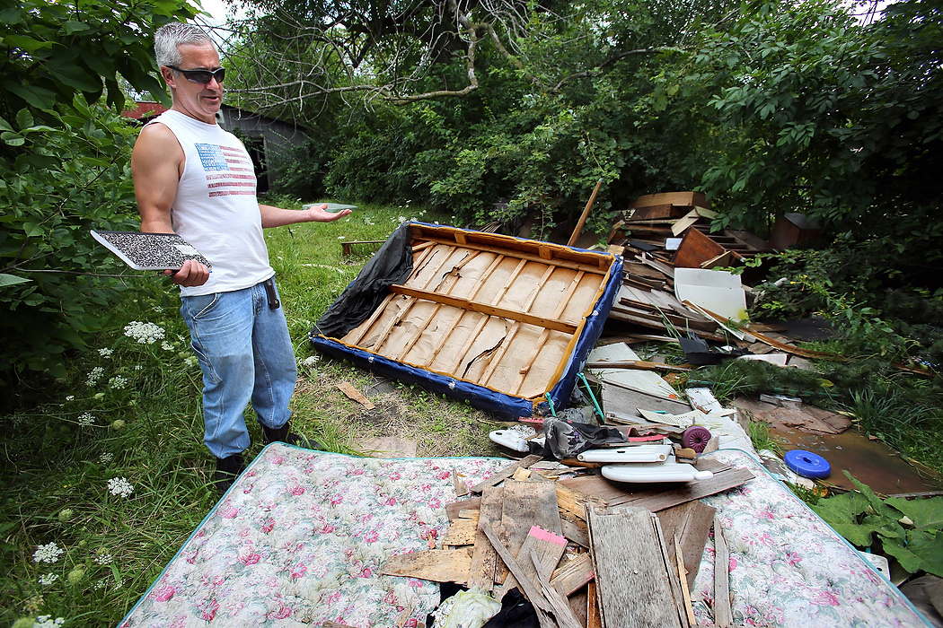 Second Place, Photographer of the Year - Large Market - Lisa DeJong / The Plain Dealer" I don't even know how to fix this ", says Blaine Murphy. "This was not a victim of the housing crisis. This was something that was falling apart for years and years."  Murphy refuses to believe he is the only one to blame for properties like this. Murphy records what he sees illegally dumped behind a vacant home on E. 76th Street.  Blaine Murphy visits this OVV property, or open, vacant and vandalized properties, on his endless code enforcement tours of Slavic Village. 