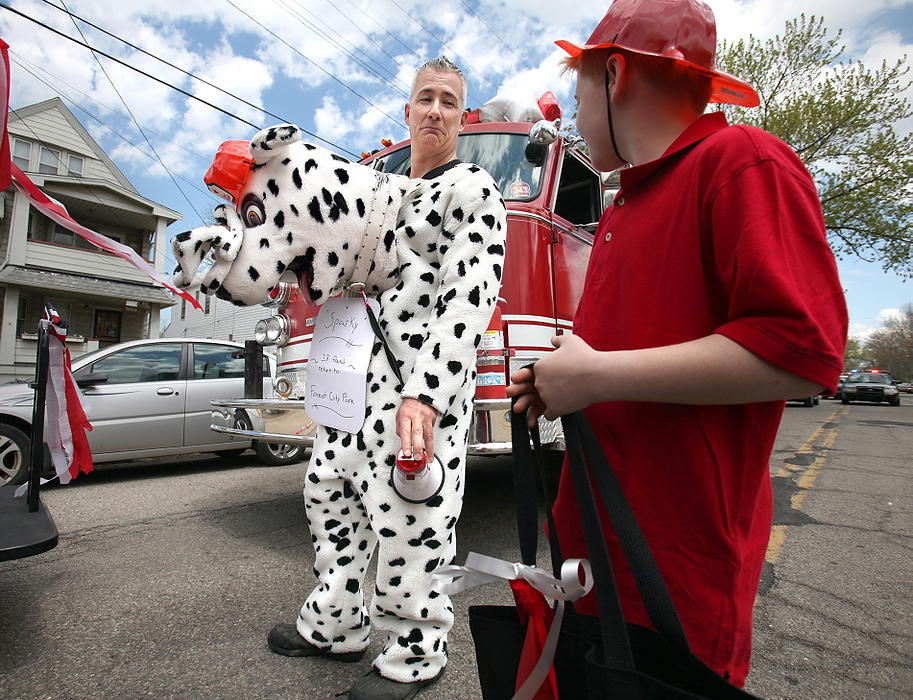 Second Place, Photographer of the Year - Large Market - Lisa DeJong / The Plain DealerCan Blaine Murphy, a convicted felon, get his neighbors to like him? Murphy, the house flipper, gets creative as he tries to fit into the small-town, working-class neighborhood of Slavic Village. Murphy's attempts to get people to like him endears Murphy to many of the old-time activists in the neighborhood. Wearing a Dalmatian suit for his ride on the fire truck, "Sparky" waits for the start of the Cleveland May 3 Polish Constitution Day Parade.  Judge Richard McMonagle released Murphy from prison to serve 3,000 hours of community service in the Slavic Village neighborhood prosecutors say he ruined by illegally flipping housing which contributed to the foreclosure crisis. Murphy begged to go back to prison instead of living among the people who would blame him for their ruined neighborhood. He feared for his safety.