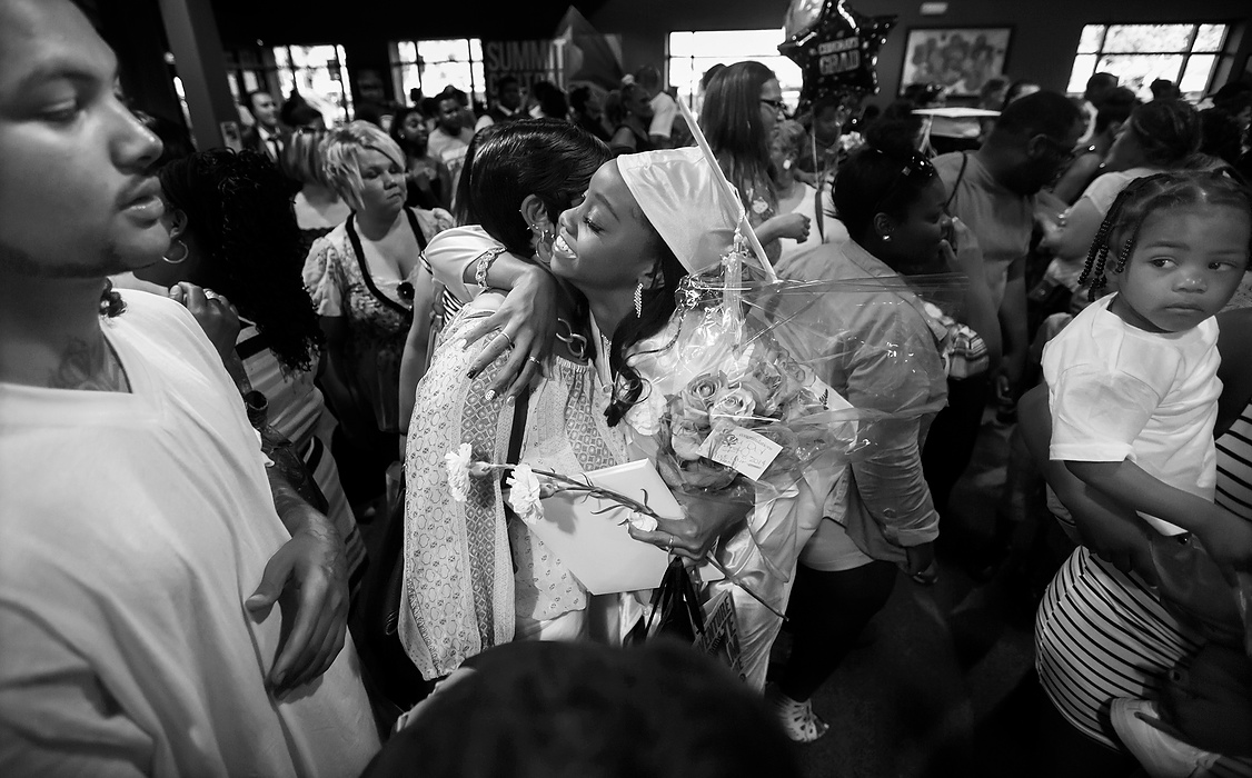 Third Place, Photographer of the Year - Large Market - Andy Morrison / The (Toledo) BladeJacqueline Moore hugs her daughter Cre'Ana Bell after the 10th Annual Commencement Exercises for Polly Fox Academy at Cedar Creek Church,   At left is Donovan Woodard, Cre'Ana's estranged boyfriend and father of their son, Cedyn Bell, 2, right. 