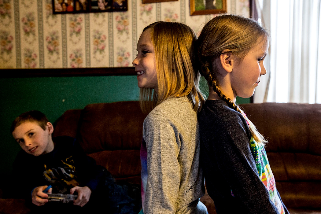 First Place, Photographer of the Year - Small Market - Jessica Phelps / Newark AdvocateAlexander laughs while his biological sister Amelia measures herself against her younger sister Ju Ju who is taller. The Deedes' biological children are all taller than their adopted children.