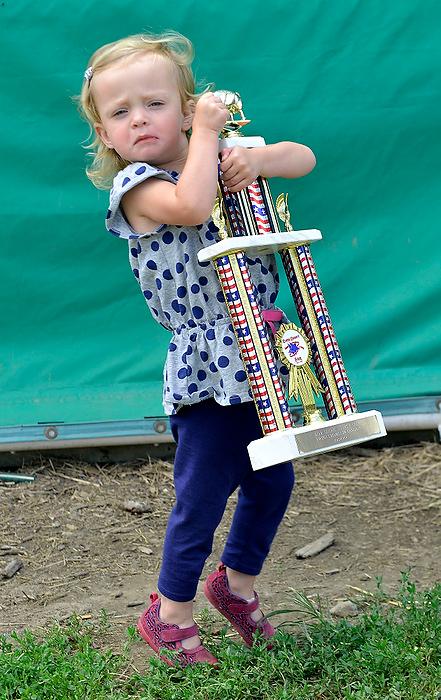 Third Place, Photographer of the Year - Small Market - Bill Lackey / Springfield News-SunKenley Ballard, 2, struggles to hold her trophy after winning the Grand Champion Swine Carcass at the fair. 