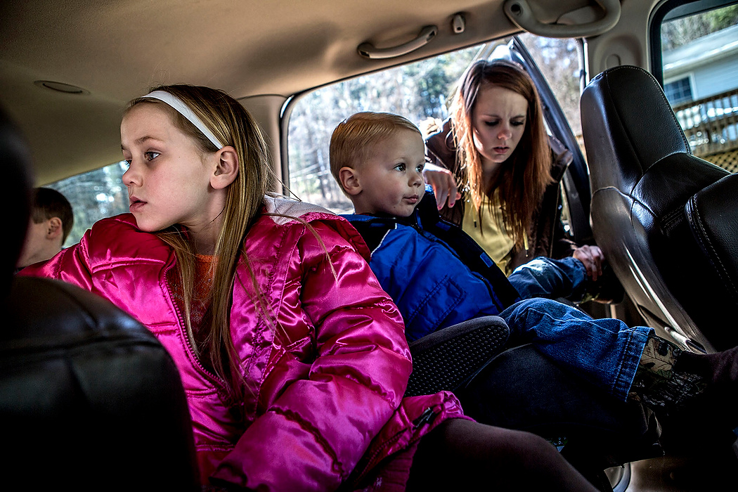 First Place, Photographer of the Year - Small Market - Jessica Phelps / Newark AdvocateMegan buckles her little brother Titus into his seat next to their sister Ju Ju. Megan tries to take care of her younger siblings in her adoptive family because she cannot  be their for two of her own younger sisters due to the way they were adopted. 