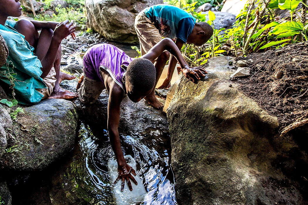 First Place, Photographer of the Year - Small Market - Jessica Phelps / Newark AdvocateLocal boys in Demier, Haiti collect water from the stream in old jugs. Because there is no clean water, chlorine tablets must be added to the water before it can be consumed.