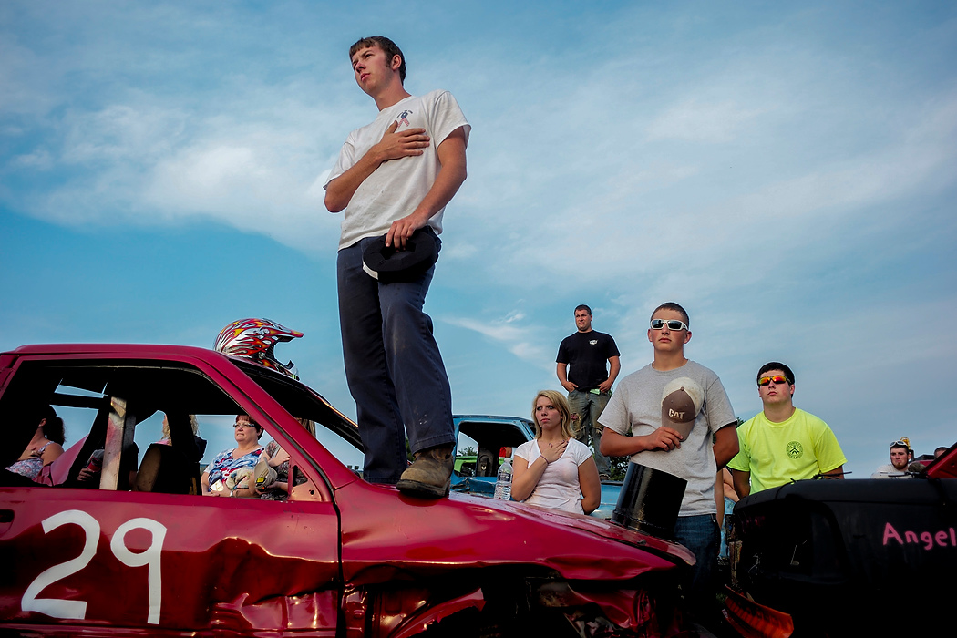 Second Place, Photographer of the Year - Small Market - Joshua A. Bickel / ThisWeek Community NewsTommy Smith, 19, of Johnstown, stands on his derby car during the playing of the national anthem before the start of the demolition derby at the Hartford Fair Aug. 6, 2014 at the Hartford Fairgrounds in Hartford. It was Smith's first competitive demolition derby.
