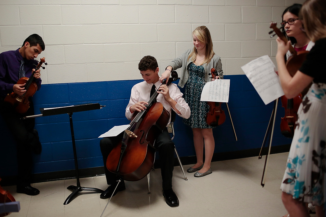Second Place, Photographer of the Year - Small Market - Joshua A. Bickel / ThisWeek Community NewsViolinist Margaret Wright, 16, center right, secretly changes the pitch of cellist Nick Jones, 16 center, as he practices his school's alma mater backstage during Central Crossing band's spring concert at Central Crossing High School in Grove City, Ohio.