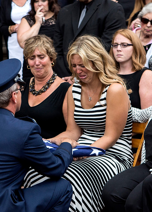 First Place, Photographer of the Year - Small Market - Jessica Phelps / Newark AdvocateAlyssa Richeson, surrounded by family and friends, is presented a flag at the funeral of her husband. Captain Nathan Richeson received full military honors at Swasey Chapel. Richeson, who grew up in Granville, served as a pilot in the Air National Guard. He was tragically killed changing a tire on the side of the road by a distracted driver. The couple were celebrating their two-year wedding anniversary.